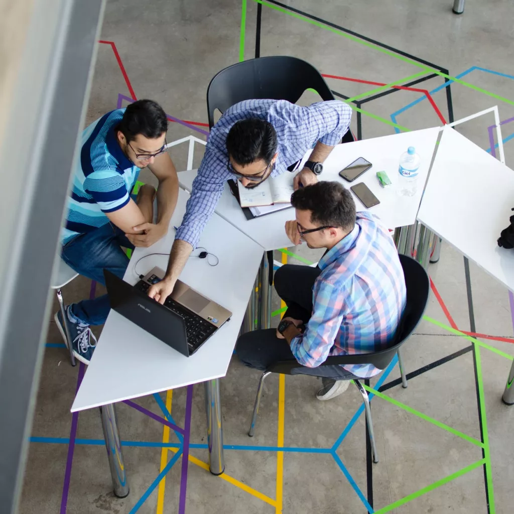 Indiegame marketing - Networking with peers - Photo by Visual Tag Mx on Pexels.com - A group of people discussing indie game marketing strategies around a table in an office.