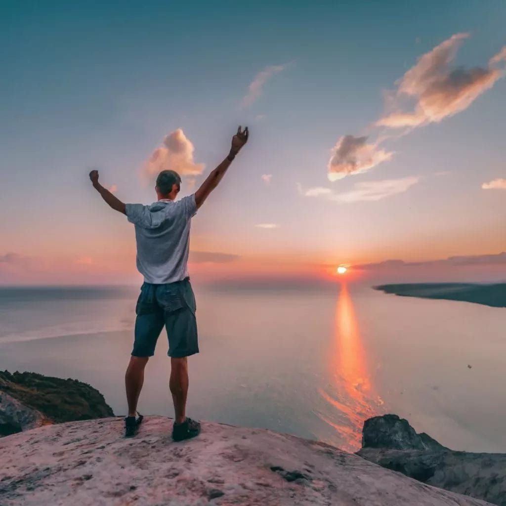 How to stay motivated as an indie game developer - Objectives and Milestones - A man standing on top of a mountain, motivated and inspired as an indie game developer.