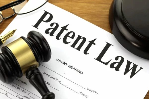 Intellectual Property Protection and Rights in the Games Industry - Patent Law and Game Development - A judge gavel sits on top of a patent law document related to Intellectual Property Protection in Video Game Development.