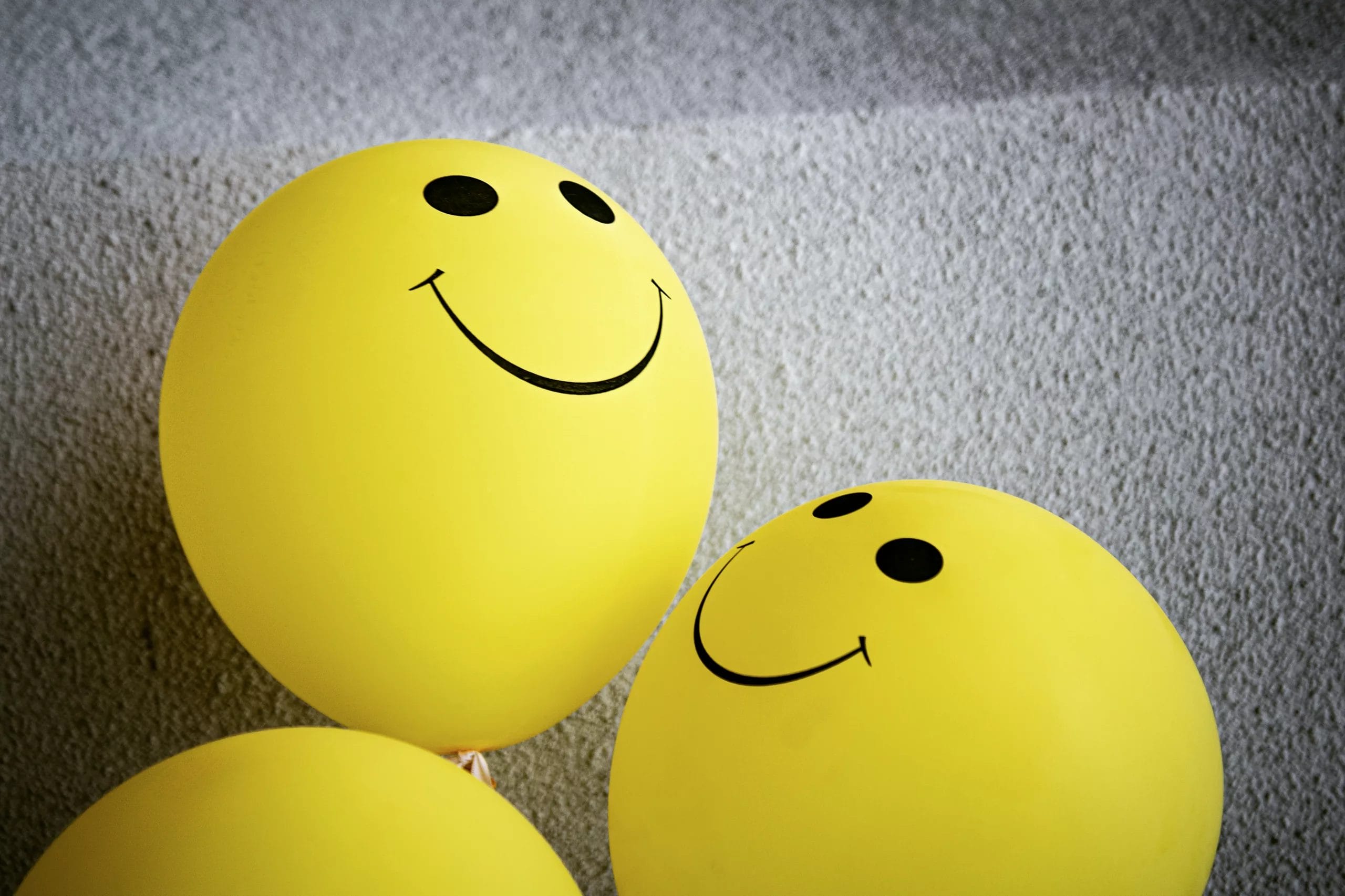 How to stay motivated as an indie game developer - Feedback and Positive reviews - Three yellow balloons with smiley faces on them at a game development event.