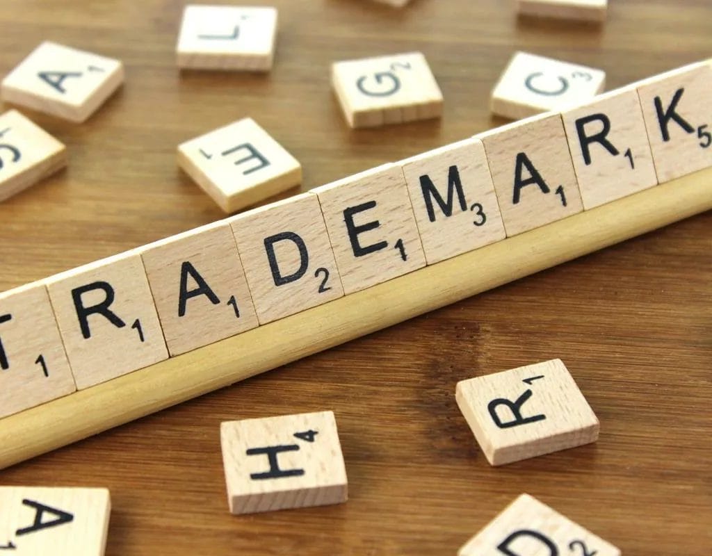 Intellectual Property Protection and Rights in the Games Industry - What is a trademark - The word trademark is spelled out on a wooden board, highlighting the importance of Intellectual Property Protection in the Games Industry.