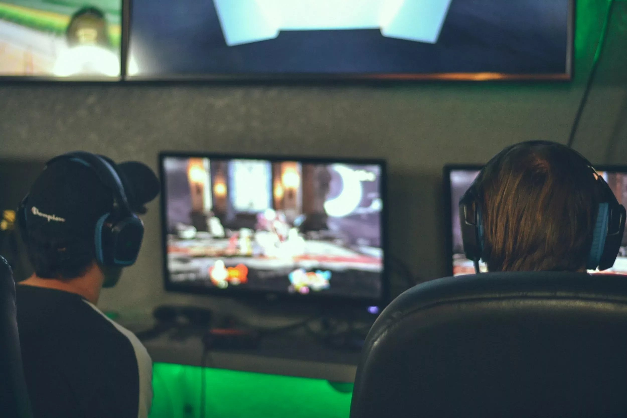 How to balance your Game - Two individuals simultaneously gaming on dual screens, showcasing the art of game equilibrium.